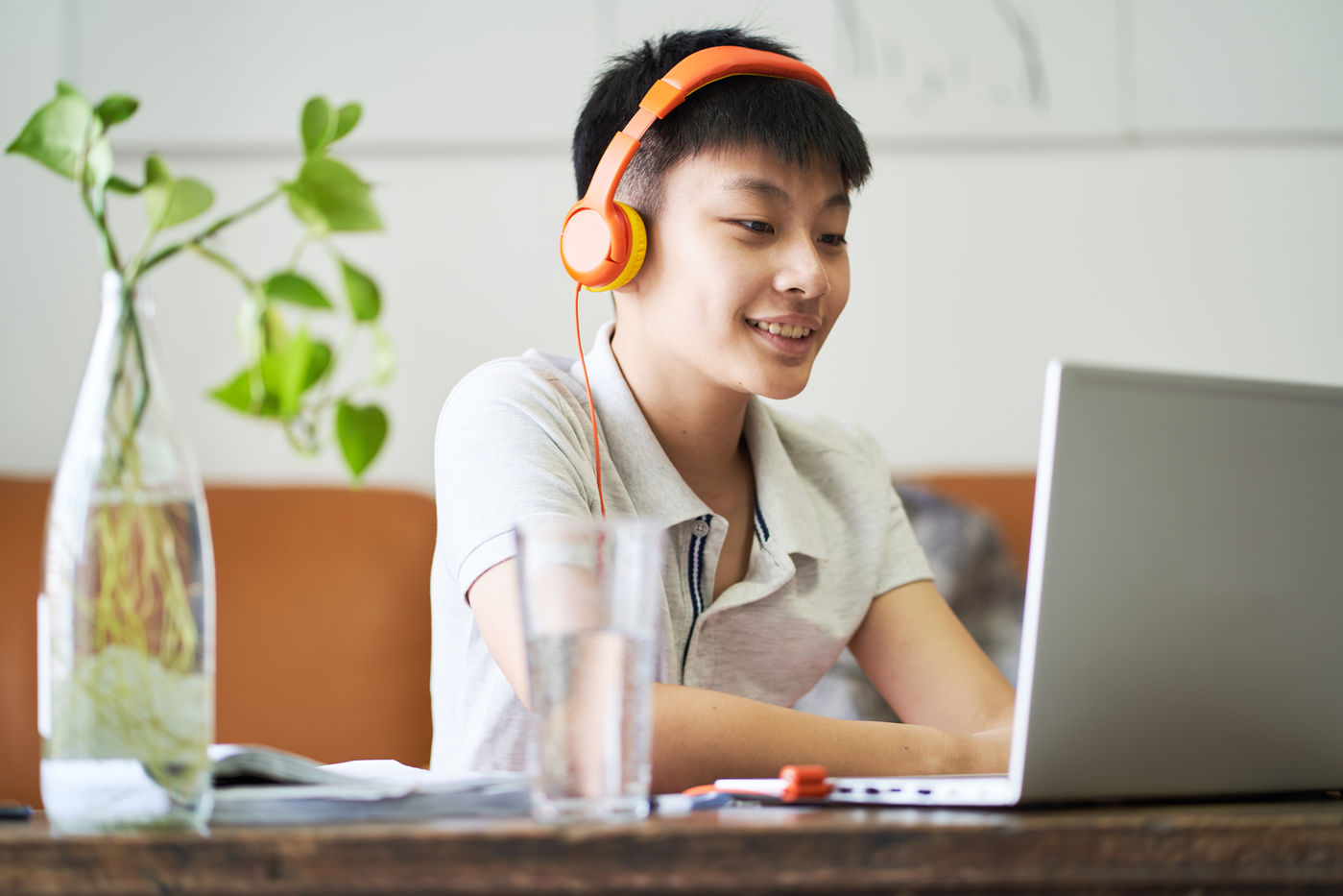 Student smiling during an online tutoring session on a laptop